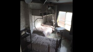 A dormitory room with two bunk beds, a desk, and a chair. - PoshtelOsaka240 (Osaka)