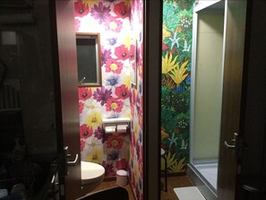 A bathroom with floral wallpaper, a sink, and a toilet.