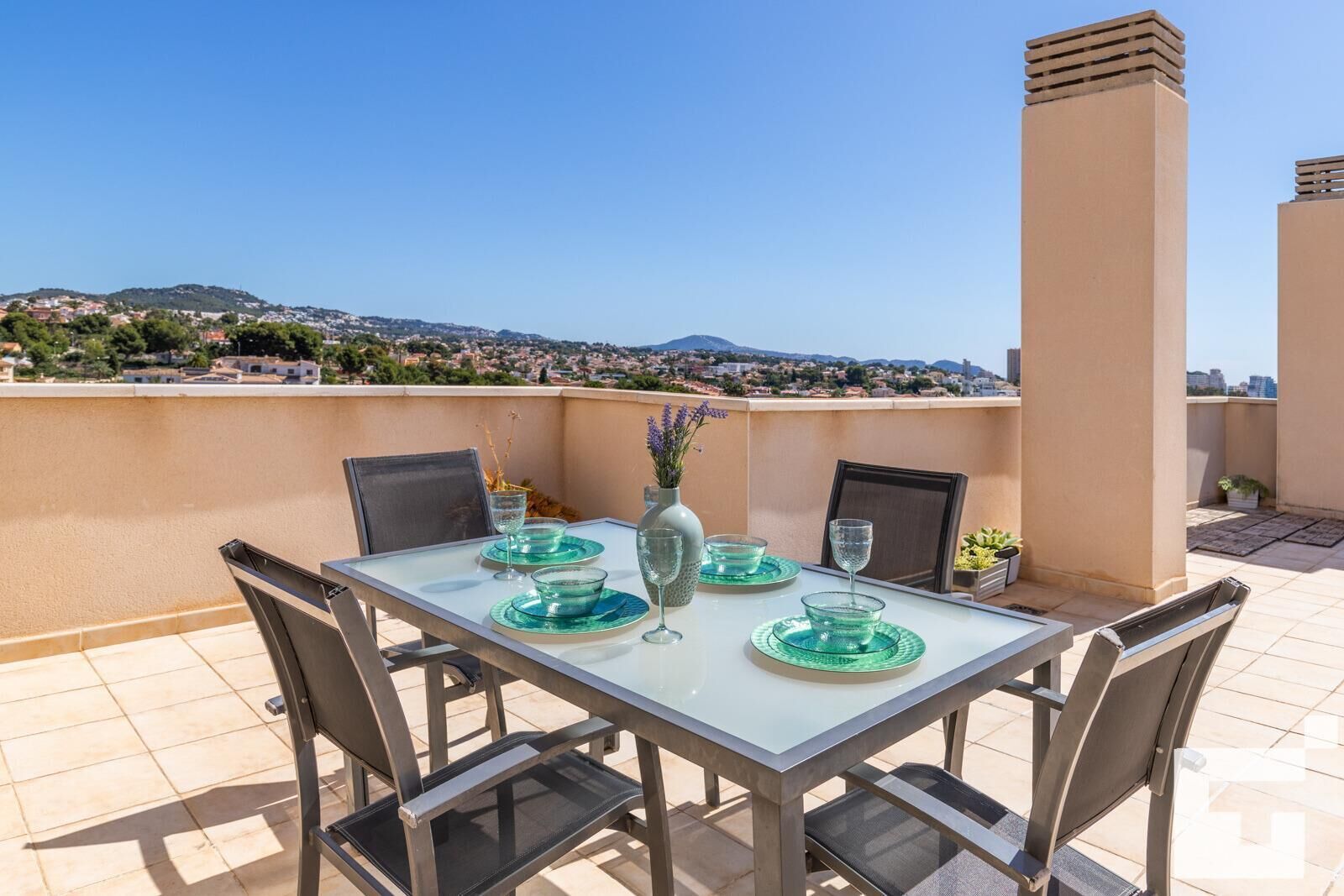 A table set for two with a clear view of a cityscape in the background.
