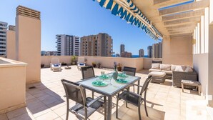 A rooftop terrace with a dining area, lounge chairs, and a view of the city skyline. - Estrella de Calpe 8C - Grupo Turis - Calpe, Costa Blanca (Calpe)