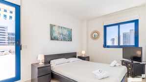 A modern bedroom with a bed, bedside tables, a TV, and a painting. - Estrella de Calpe 8C - Grupo Turis - Calpe, Costa Blanca (Calpe)