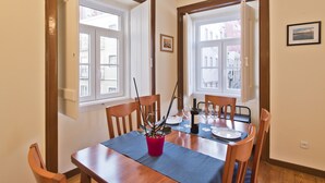 A dining area with a wooden table, chairs, and a potted plant.