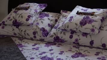 Ein Bett mit blumigem Bettzeug und zwei Snickersriegeln auf den Kopfkissen.