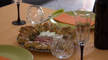 Een tafel met verschillende soorten eten, wijnglazen en borden.