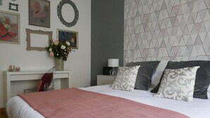 Ein ordentlich eingerichtetes Schlafzimmer mit Bett, Nachttischen, einer Lampe und dekorativen Elementen an der Wand.