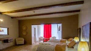 A hotel room with a bed, two chairs, a small table, and a red curtain. - Dana Guest House (Dana)