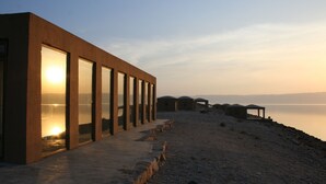 Un bâtiment moderne doté de grandes fenêtres, situé au bord de l’eau.