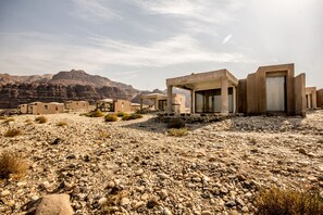 A desert landscape with multiple buildings featuring simple, modern architecture.