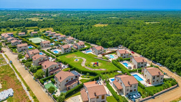A residential area with multiple two-story houses, a swimming pool, and a tennis court.