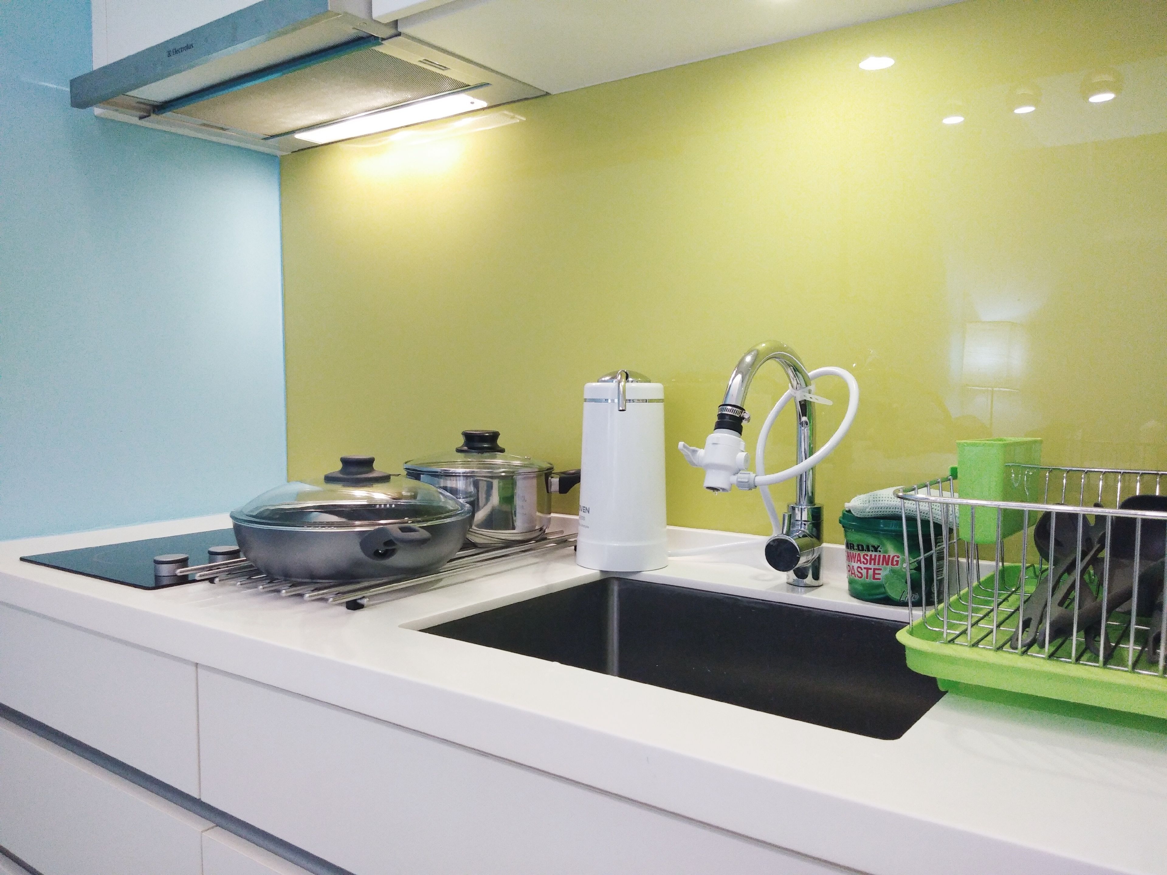 A kitchen with a sink, a dish rack, and a water dispenser.