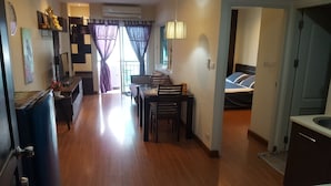 Un espacio habitable compacto con comedor, cama y kitchenette.