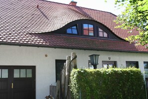 A house with a red-tiled roof, a dark wooden door, and a window with a black frame. - Apartment Levien, Germany (Wustrow)