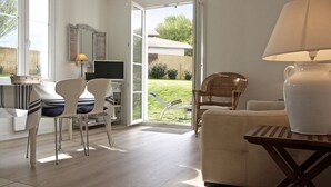 A bright room with a desk, chairs, a sofa, and a lamp. - Appartment Ihi-Toki, sunny garden apartment in a breathtaking location (Saint-Pée-sur-Nivelle)