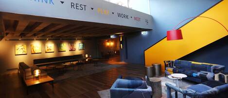 A modern lounge area with seating and artwork on the walls.