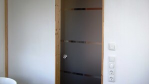 Una habitación con una puerta de madera, una pared blanca y un interruptor de luz.