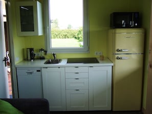 A compact kitchen with a window, a Siemens dishwasher, a sink, and a refrigerator.