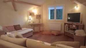 Un dormitorio acogedor con cama, televisor, escritorio y ventana.