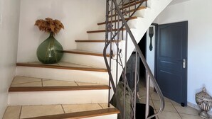 A staircase with a metal railing, a green vase, and a blue door. - Near Avignon, Comfortable villa with private pool, in Provence  (Althen-Des-Paluds)