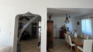 A spacious living area with a dining table, chairs, a staircase, and a kitchen area. - Near Avignon, Comfortable villa with private pool, in Provence  (Althen-Des-Paluds)