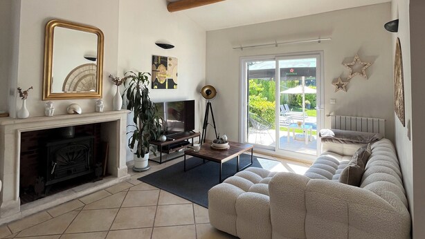 A living room with a fireplace, sofa, and large windows. - Near Avignon, Comfortable villa with private pool, in Provence  (Althen-Des-Paluds)