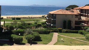 Un hôtel en bord de mer offrant une vue sur la plage, doté d’un jardin et bénéficiant d’un ciel dégagé.