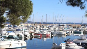 Un port de plaisance où de nombreux bateaux sont amarrés, l’eau est calme et le ciel est dégagé.