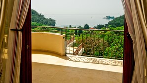 A balcony with a view of a body of water and greenery. - St. George Apartments and Villa with pool (Petrovac)