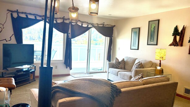Un salon avec un canapé, un téléviseur, une table basse et une lampe.