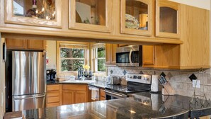 Una cocina moderna con armarios de madera, electrodomésticos de acero inoxidable y una amplia encimera de granito.