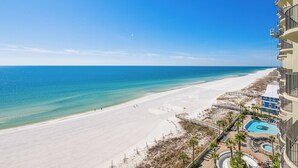 A beach view with a swimming pool and a building with balconies. - 9th Floor BEACH FRONT 3 Bedroom! Phoenix West LAZY RIVER (Orange Beach)