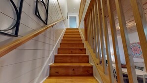 A wooden staircase with white walls and a wooden railing. - Pet Friendly, Located in Town, Close to beach, Shared Pool, Golf Cart Access (Port Aransas)