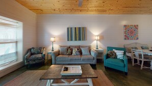 A cozy living room with a wooden ceiling, a sofa set, a coffee table, and two lamps. - Pet Friendly, Located in Town, Close to beach, Shared Pool, Golf Cart Access (Port Aransas)