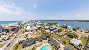 A coastal residential area with a large swimming pool, multiple buildings, and a clear view of the ocean. - Crystal Tower 1509 - Luxurious 15th Floor Corner Condo with Breathtaking Views (Gulf Shores)