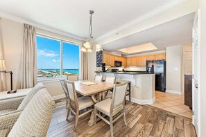 Une cuisine moderne avec des meubles en bois, un îlot central et une vue sur l’océan.