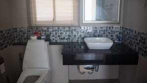 A bathroom with a toilet, sink, and window. - Villa Somewhere Phuket Laguna Bangtao (Choeng Thale)