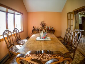 A dining room with a large wooden table, ornate chairs, and a decorative centerpiece. - Log Cabin with Hot Tub, Sauna, Private Pond, 23 acres -- 4.6 mi to Bethel Woods (Cochecton)