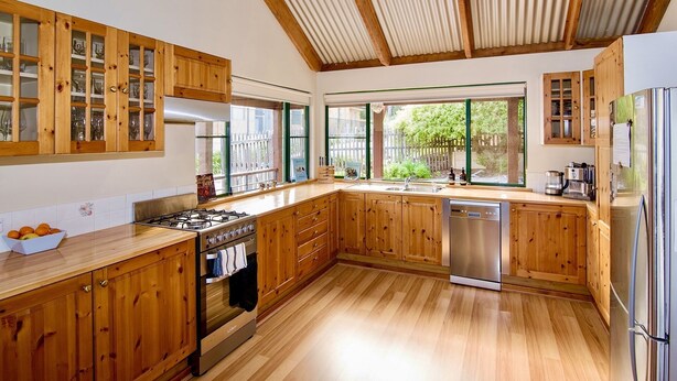 A kitchen with wooden cabinets, a gas stove, a dishwasher, and a refrigerator. - 5 bedroom 2 bathroom family beach house with glimpses of Geographe Bay (Dunsborough)