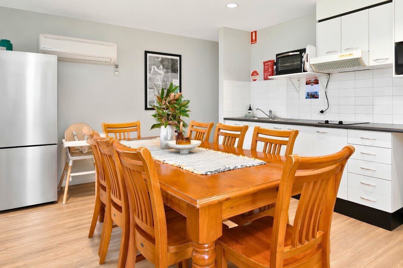 A modern kitchen with white cabinets, a built-in microwave, and a stainless steel refrigerator.