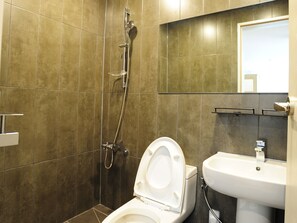 A modern bathroom with a shower, toilet, and sink.