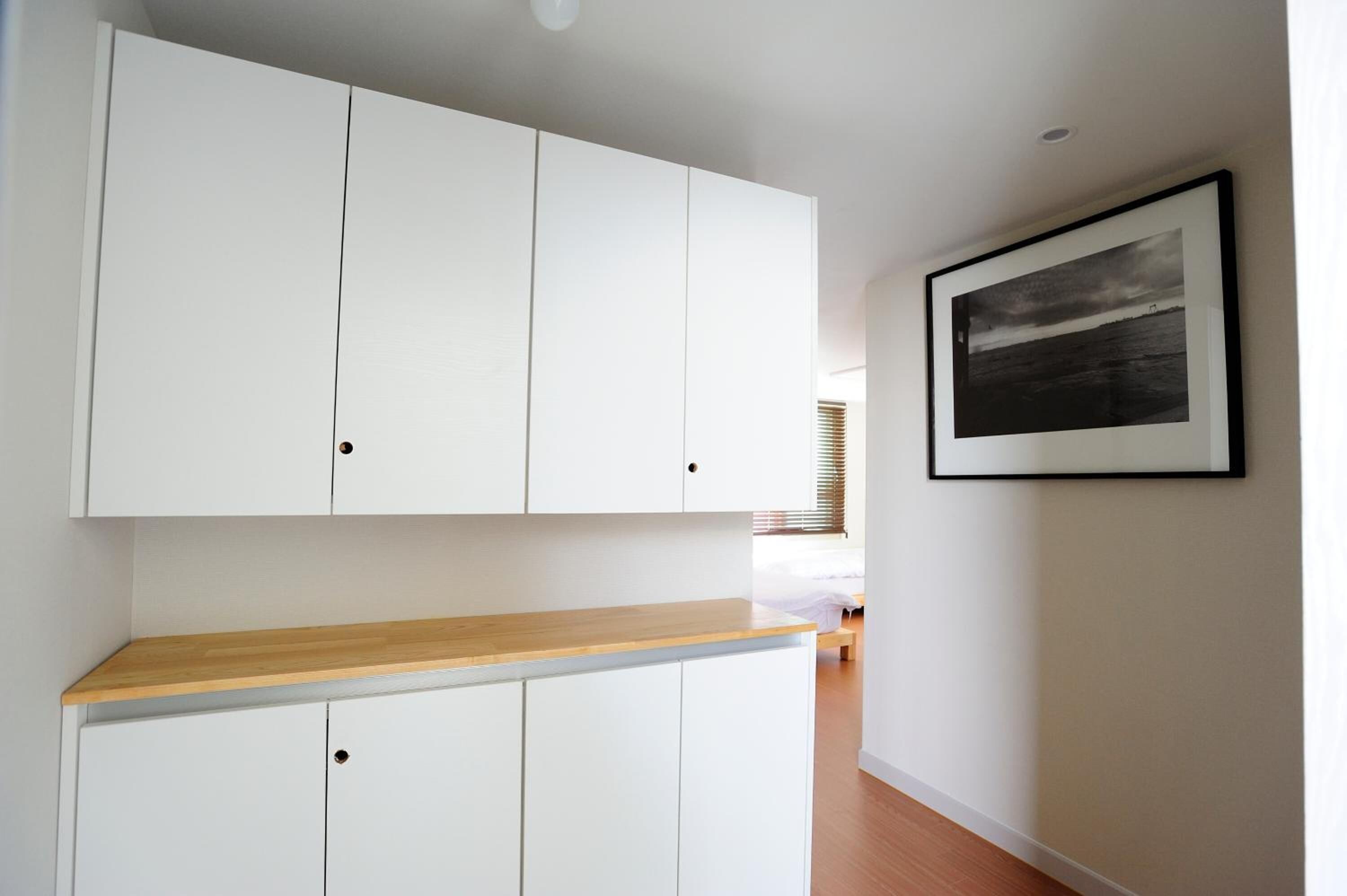 A modern kitchen with white cabinets and a wooden countertop.