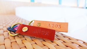 Una superficie tejida con dos etiquetas de cuero, una roja y otra naranja, cada una con texto en relieve.
