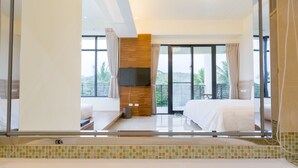 A modern hotel room with a large bed, a TV mounted on the wall, and a balcony with a view of palm trees. - Rich Sunshine Inn (Beinan)