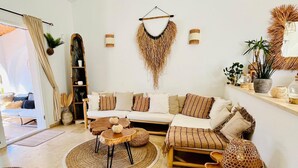 Ein gemütliches Wohnzimmer mit einer Couch, einem Couchtisch und dekorativen Teppichen.