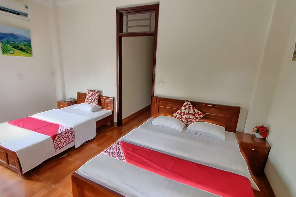 A hotel room with two beds, wooden headboards, and a large mirror.