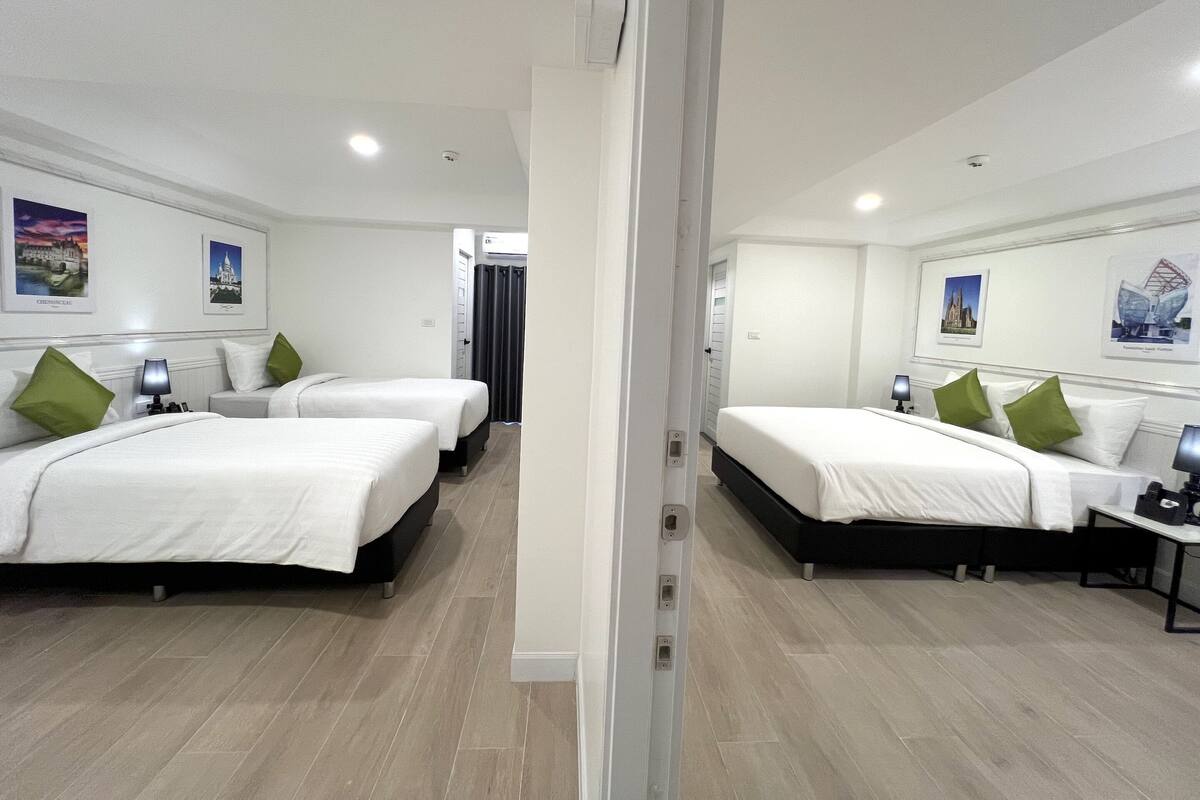 A hotel room with two beds, a desk, and a chair.