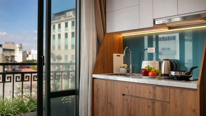 Une cuisine moderne avec des meubles en bois, une hotte de cuisine en acier inoxydable et une fenêtre donnant sur un paysage urbain.