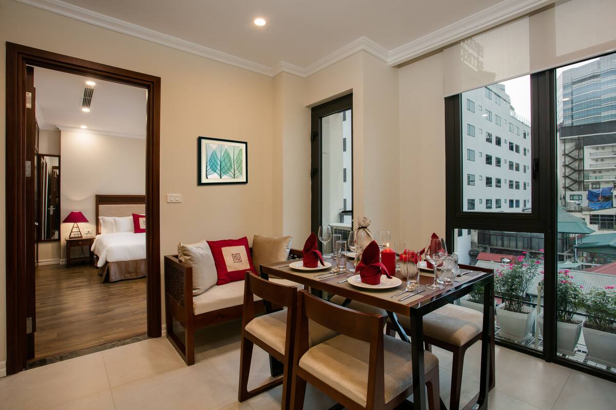 Une chambre d’hôtel comprenant un coin repas, un lit et une vue sur la ville.