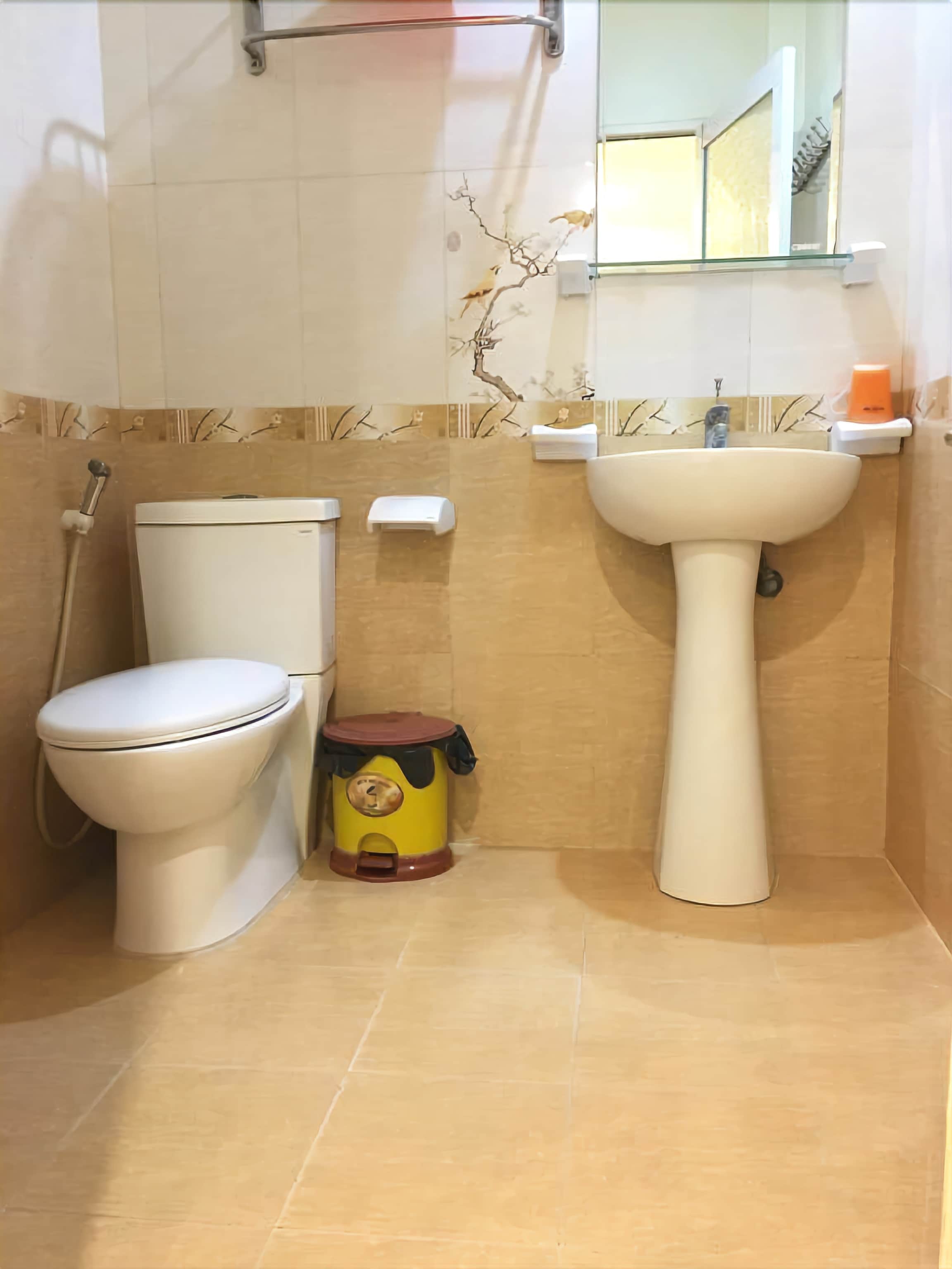 A bathroom with a toilet, a sink, and a shower.