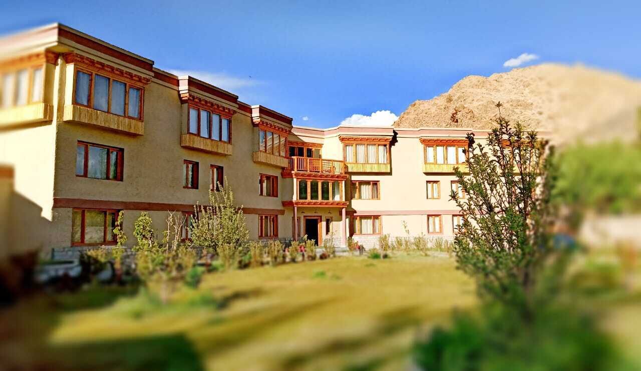 Un hotel de varios pisos con balcones y un patio interior.