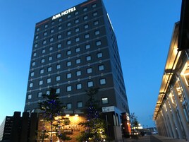 Un hotel de varios pisos con un llamativo letrero que dice "AM HOTEL" en la parte superior.